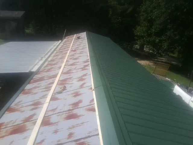 Old rusted panels beside newly installed green metal roofing — Wind Damage Roof Repair by Roofing Brothers in Coppell