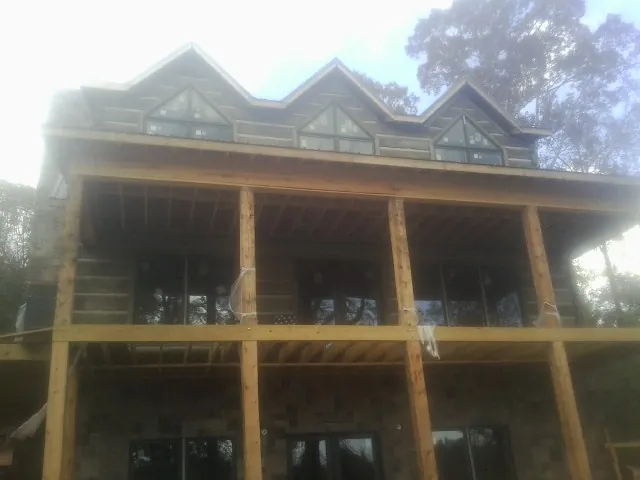 Dormers and porch framing on a large log home under construction — Roof Coating work by our crew in Coppell
