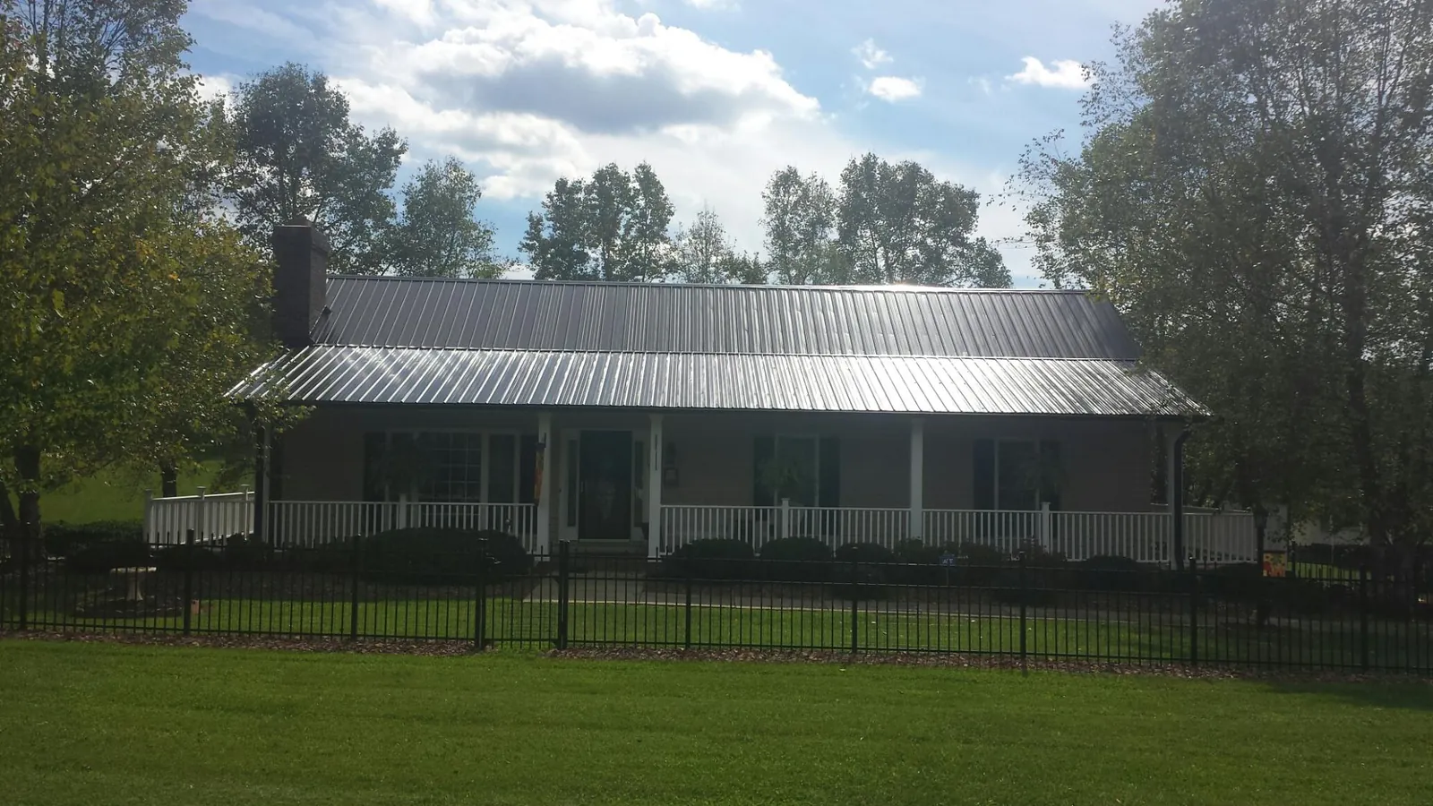 Gray metal roof on a brick ranch with a full width front porch — Gutter Guard Installation work by our crew in Coppell