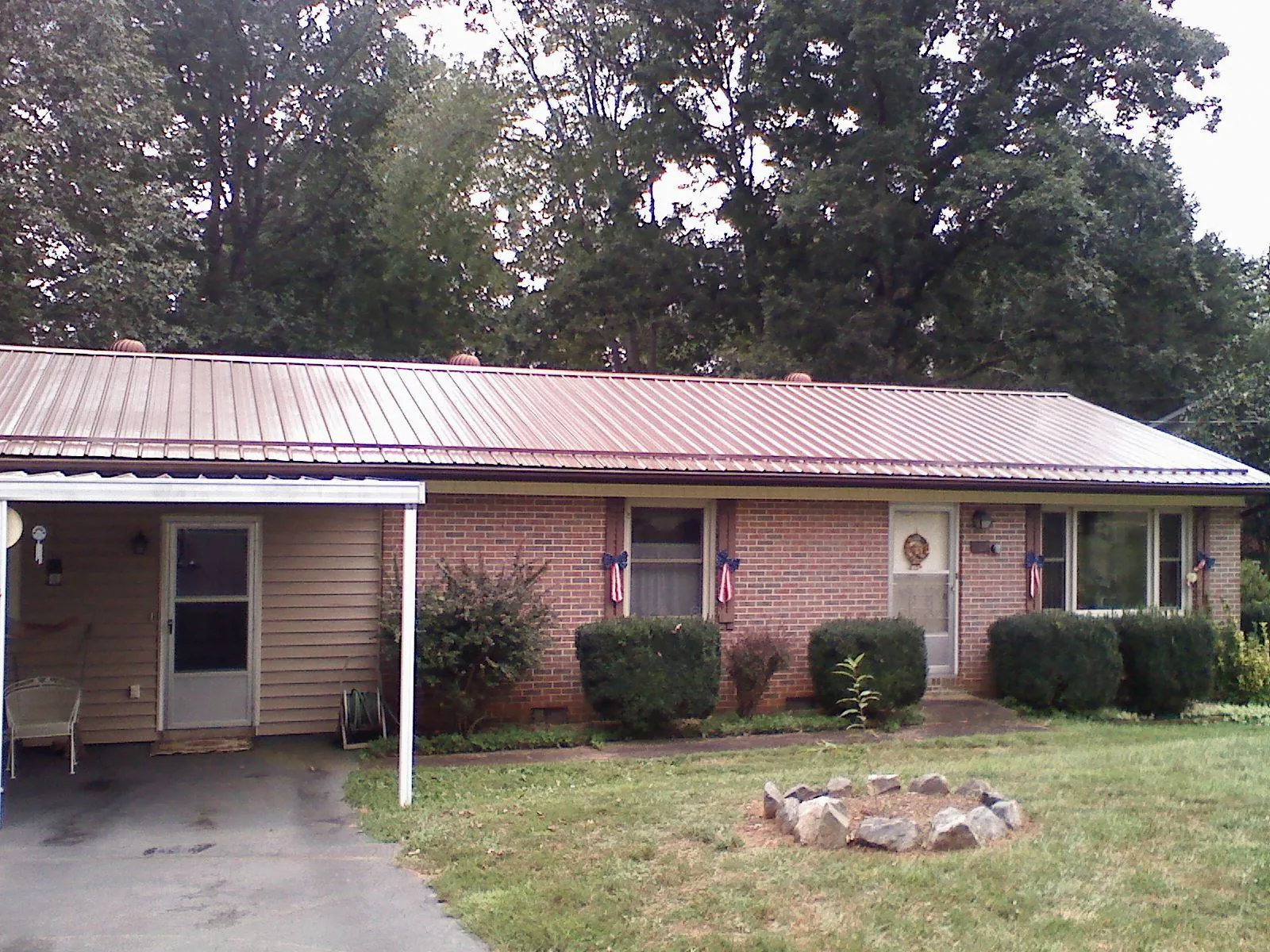 Bronze metal roof and carport on a brick ranch home — Roof Repair work by our crew in Coppell