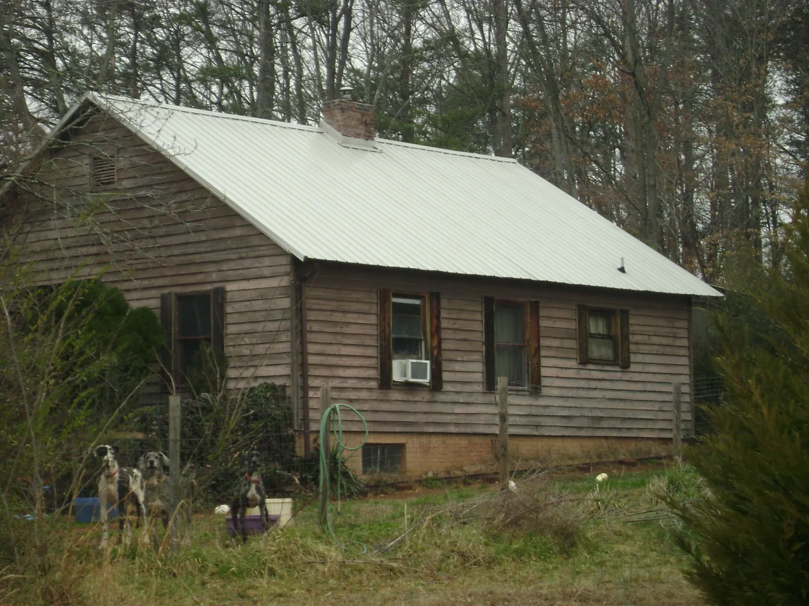 White metal roof on an old wood sided farmhouse, from a Metal Roof Installation job in Coppell